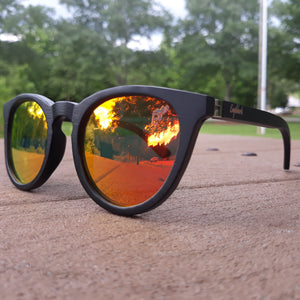 sunset mirror sunglasses with black wood arms outdoors